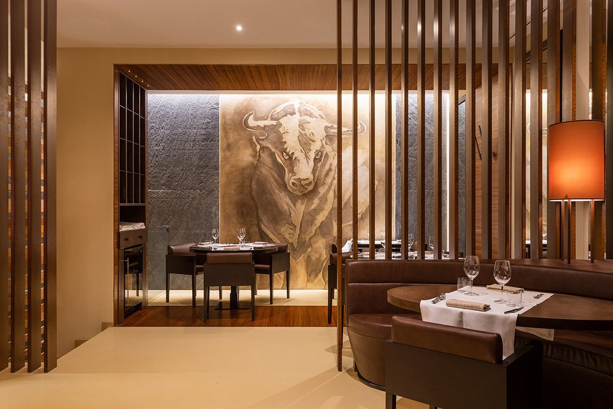 La sala con il toro dipinto sulla parete di pietra, dietro le lamelle di legno